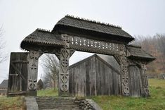 an old wooden structure in the middle of a grassy area with stairs leading up to it