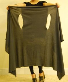 a woman is holding up a large piece of cloth with holes cut out on it