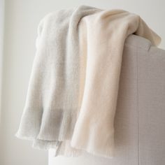 a white blanket hanging on the back of a couch