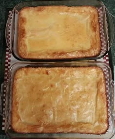 two pans filled with food sitting on top of a counter next to each other