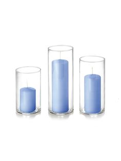 three blue candles in glass vases on a white background