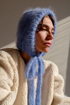 The Brushed Mohair Bonnet is your fluffy new best friend. Hand-knit in our signature super soft mohair, it delivers warmth and comfort while offering a playful twist to classic headwear. Its long, textured ribbons allow you to tie it either at the front or at the back, giving you styling flexibility to suit any look or mood. Wear it snug for full coverage or draped loosely as a hood for a more relaxed vibe. Handcrafted in Greece. DETAILS * Super soft, premium quality Italian mohair * 60% kid moh Mohair Projects, Mohair Bonnet, Cute Winter Hat, Winter Bonnet, Brushed Mohair, Mohair Hat, Knitted Bonnet, Crochet Bonnet, Knit Bonnet