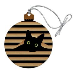 an ornament with a black cat on it's face and green eyes