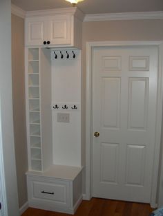 an empty room with two white doors and some shelves on the wall next to each other