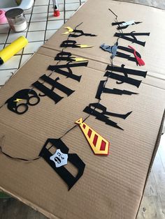 a cardboard sign that says happy birthday with cut out letters and scissors on top of it