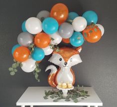 an animal balloon bouquet on a table with balloons in the shape of animals and leaves