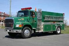 a green fire truck parked in a parking lot