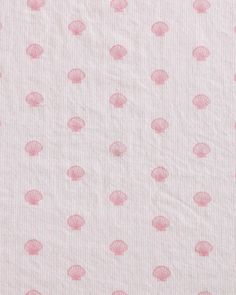 a pink and white polka dot fabric with small shells on the bottom of it,