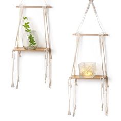 two wooden shelves with plants on them against a white wall, one holding a glass vase and the other hanging from strings