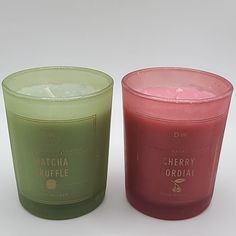 two candles sitting next to each other on a white surface with the words matcha ruffle and cherry orchid