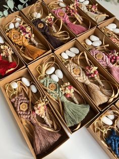 many different types of tassels in boxes on a table with flowers and eggs