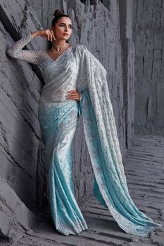 Ice blue ombre saree with silver sequin embroidered floral motifs. Paired with blouse.
Components:2
Pattern:Embroidery
Type of Work:Sequin, floral
Neckline:Deep V neck
Sleeve Length:Full sleeves
Fabric:Butterfly net, satin georgette
Color:Blue
Other Details:
Scallop bordered saree
Embroidered blouse
Back tassel detailing
Back cut-out
Closure: Blouse: Hook and eye
Occasion:Destination Wedding - Aza Fashions Ombre Saree, Engagement Saree, Butterfly Net, Saree Wearing Styles, Full Sleeve Blouse, Fancy Sarees Party Wear, Ghagra Choli, Satin Saree, Net Saree