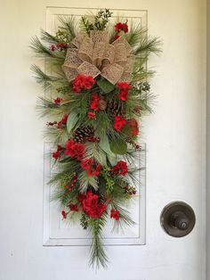 a door decorated with red flowers and pine cones