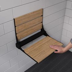 a person holding onto a wooden bench in a bathroom