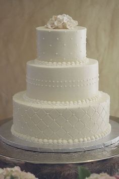 a white wedding cake sitting on top of a table