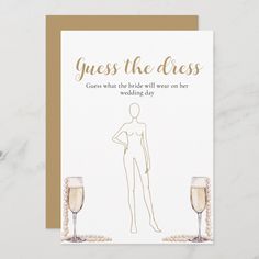 a card that says guess the dress and two champagne glasses next to it on a marble surface