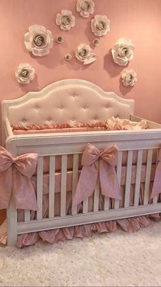 a baby crib with pink and white flowers on the wall