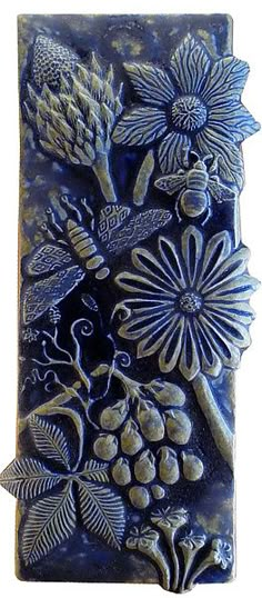 a ceramic tile with flowers and leaves on it