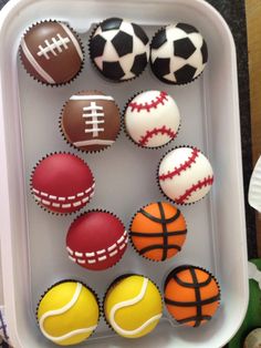 cupcakes decorated with sports balls in a tray