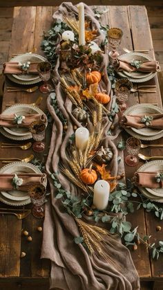 a wooden table topped with plates and candles