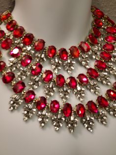 "Hello, welcome to Ken's Closet *My camera didn't like the red color* All red crystals are the same color. In the picture, they look like a mixture of red, pink, and orange. Today we have a beautiful 3 strand Ruby Red and Diamond Clear Crystal Necklace. The crystals are set in gold metal, they really bring out the color. Large crystals are accented by smaller Clear crystals. The necklace is appx 18\" long total. The hang is appx 5\" from the center top stand to the bottom 3rd strand. Crystals ar Clear Crystal Necklace, Burlesque Costume, Crystal Diamond, Gold Alloys, Jewelry Studio, Black Chandelier, Red Crystals, Large Crystals, Diamond Crystal