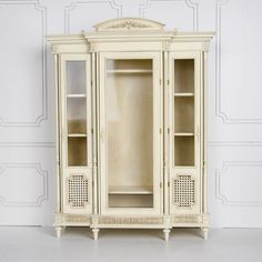 an antique white china cabinet with glass doors