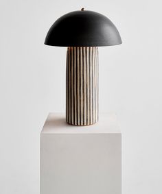 a black and white lamp sitting on top of a table next to a white block