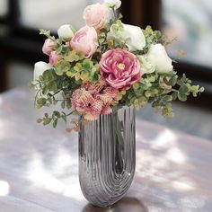 a vase filled with flowers on top of a wooden table