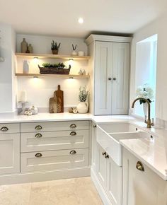 a kitchen with white cabinets and counter tops