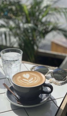 a cappuccino on a saucer with a spoon in it sitting on a table