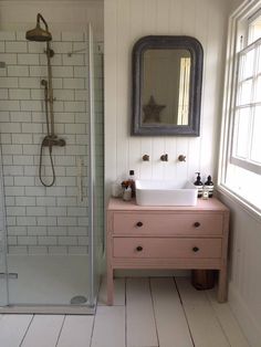 a bathroom with a sink, mirror and bathtub in the shower area is shown