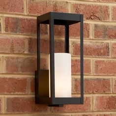 an outdoor light mounted on the side of a brick wall