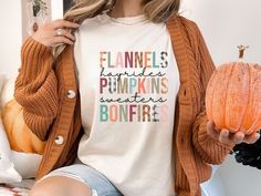 Autumn fall womens tee shirt. Pumpkins, leaves, cozy sweater and Hot Chocolate & Bonfires on this  🌟Premium Comfort Colors Shirt will bring a smile. Super Soft and will surely be your next favorite T shirt. 🌺Welcome to TarryTown Goods🌺 UNISEX Comfort Colors C1717 T-SHIRTS The Models in the pictures are wearing 1 or 2 sizes up, Please order 1 or 2 sizes up for an oversized look. About Comfort Colors C1717 These ultra soft pigment dyed shirts are best sellers, 100% Cotton. ⭐️ 100% ring spun cot Cozy Fit Graphic Print Tops For Fall, Cozy Short Sleeve Tops For Fall, Cozy Relaxed Fit T-shirt For Fall, Relaxed Fit T-shirt For Fall, Cozy Graphic Print T-shirt For Fall, Thanksgiving Tee, Cozy Gift, Dye Shirt, Cozy Sweater