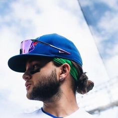 a man with a ponytail wearing a baseball cap