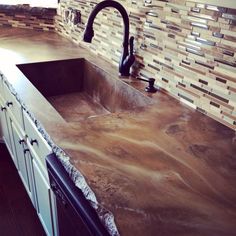 a kitchen counter top with a sink and faucet in the middle of it