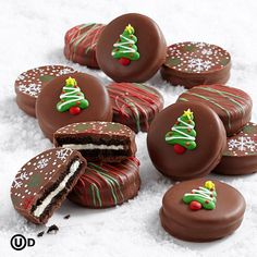 chocolate covered cookies with christmas decorations and frosting on them are shown in the snow