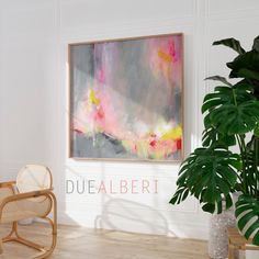 a painting hanging on the wall next to a chair and potted plant in front of it