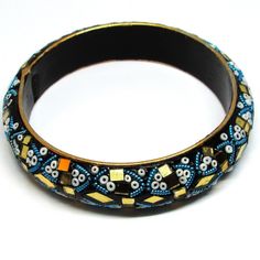 This is a truly unique and beautiful bohemian piece. Made of clay and is embellished with multi-coloured seed beads, coiled wire and is decorated with golden mirrored pieces. This bangle has INDIA carved on the inside, as per last photo. Bought from an estate sale, this piece is used and has minor signs of wear. Please look at the photos for a more accurate view of condition. Bohemian Bangle Bracelets With Gold Beads, Bohemian Bangle Bracelet With Gold Beads, Bohemian Gold Beads Bracelets For Party, Bohemian Gold Beads Bracelet For Party, Bohemian Gold Beaded Bracelets For Party, Bohemian Gold Beads Bangle Jewelry, Bohemian Bangle With Gold Beads, Unique Embellished Festival Jewelry, Unique Beaded Bangle Bracelets For Festival