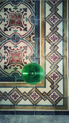 a green light switch on the side of a tiled wall in an old style bathroom