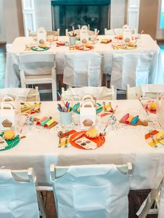 the table is set for an event with white linens and bright colored napkins