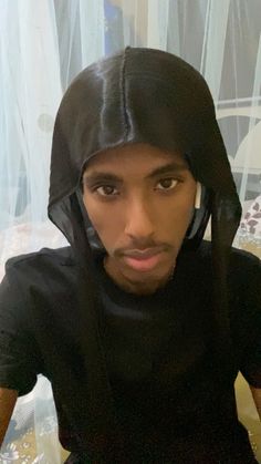 a man in black shirt and hoodie taking a selfie