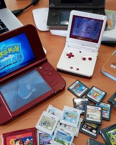 several nintendo games are sitting on the table next to laptops and other electronic devices