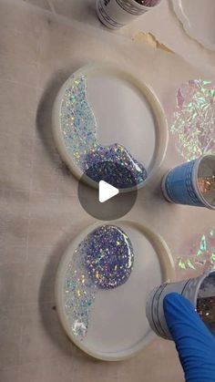 three plates with glitter on them are being painted