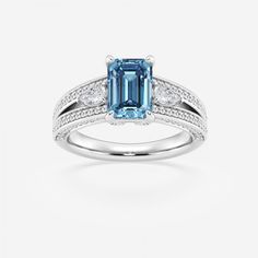 an aqua blue and white diamond ring with diamonds on the sides, set in 18k white gold