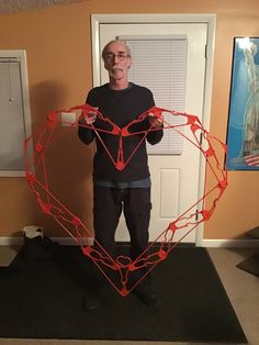 a man standing in front of a heart shaped object