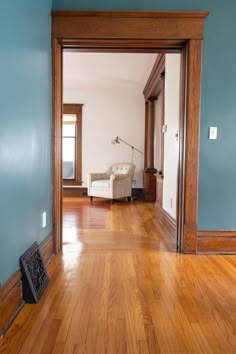 an empty room with hard wood floors and blue walls