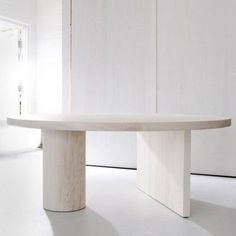 a large white table sitting in the middle of a room next to a doorway and window