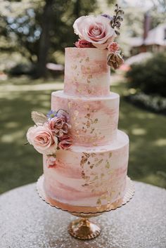 a three tiered cake with pink flowers on top