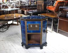 several tables and chairs in a room with wooden floors, one has a blue glass top