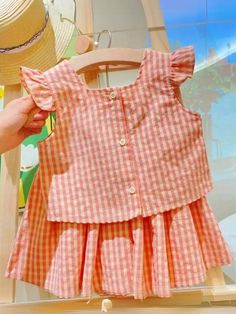 Treat your darling to sweet sophistication with a pink gingham skirt set that shows off her natural charm. A pretty pink colorway decorated with lovely ruffles and a statement-making bow, plus a matching skirt creates perfect twirls for your little girl. Soft, lightweight fabric keeps her cool and comfy even on warm days. Pre-styled with pieces that work all year round. Easy to mix and match with her other faves. Perfect for spring, casual outings, fashion photoshoots, and year-round style adventures Set includes pink gingham flutter sleeve top with statement bow accent and matching pink gingham skirt Available in sizes 2T-6Y for toddlers and little girls Woman Costumes, Birthday Sweater, Girl Soft, Gingham Skirt, Kid Clothes, Baby Dresses, Girls Outfits, Kids Corner, Pink Gingham